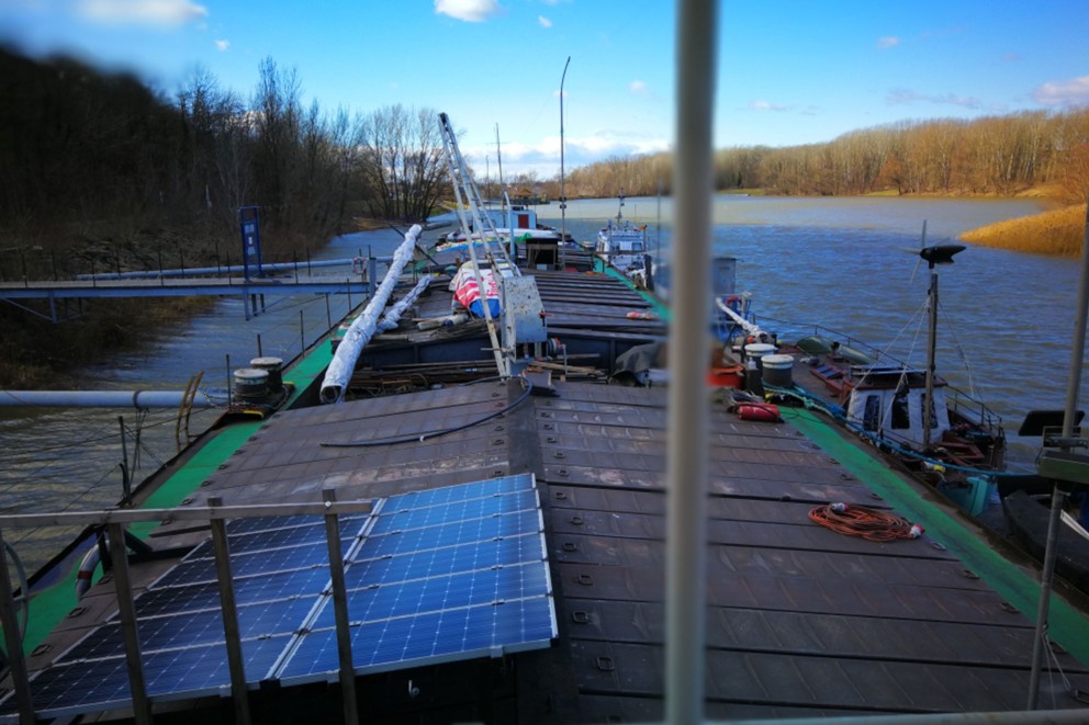 
				Des panneaux solaires sur le toit: la péniche atelier sur les rives du Danube.

			