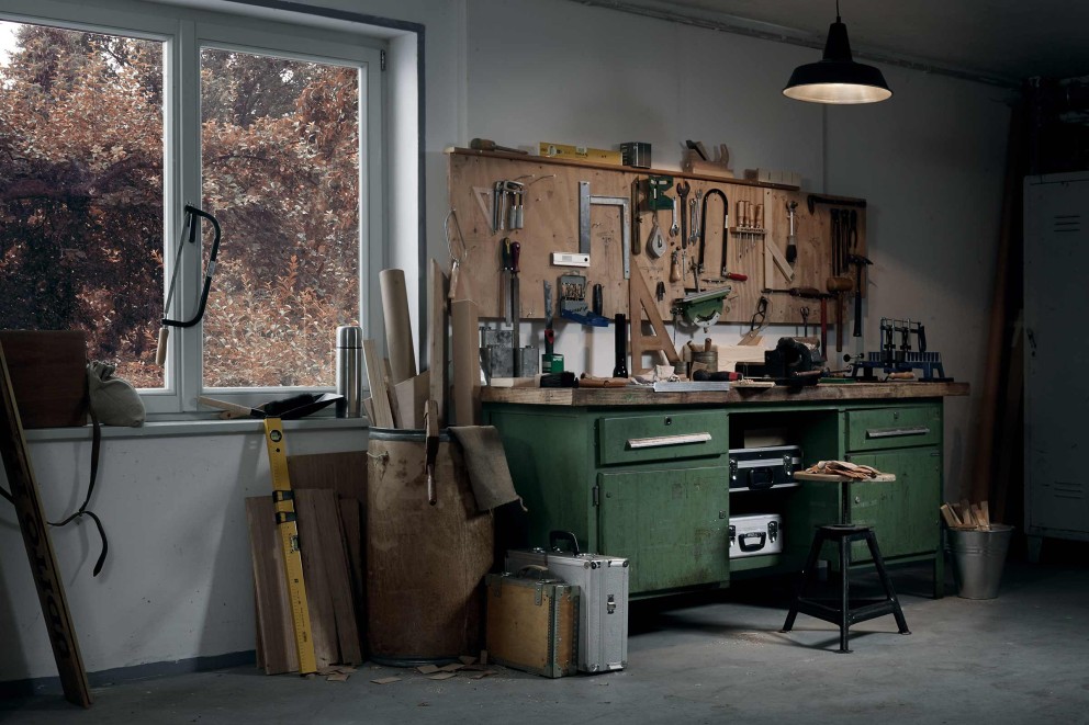 Atelier avec établi, outils, pièces et coffres à outils.