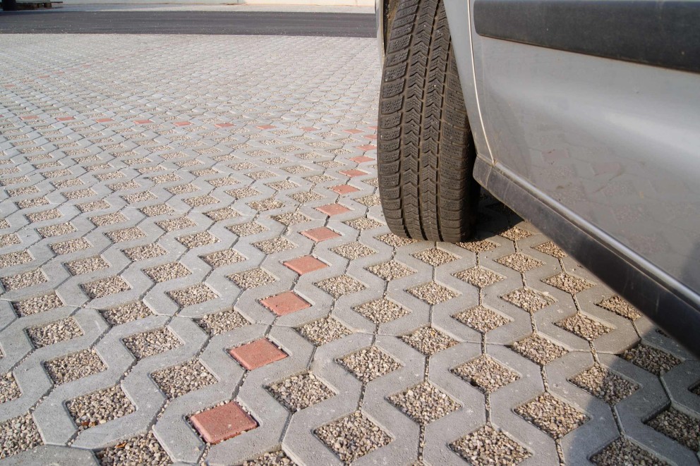 Surface aménagée avec une dalle stabilisatrice et du gravier sur laquelle est garée une voiture Surface aménagée avec une dalle stabilisatrice et du gravier sur laquelle est garée une voiture