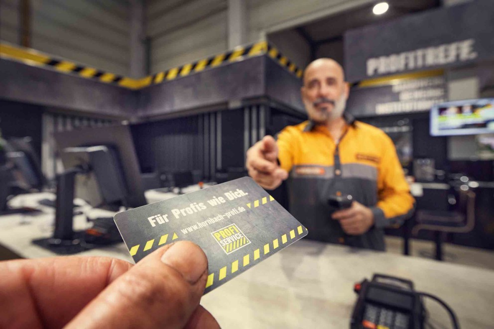 Un collaborateur de Hornbach tend une carte de service Pro.