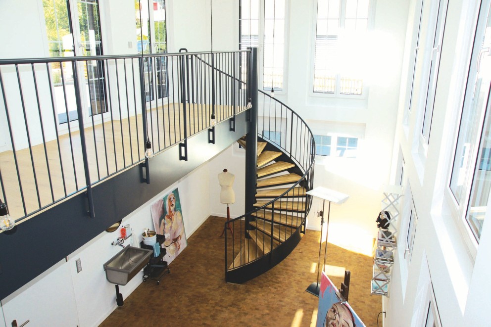 Pièce lumineuse avec escalier en colimaçon, lavabo et équipement d'atelier