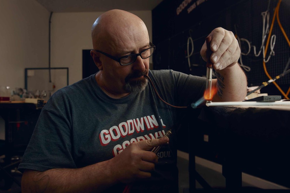 
				Feu et travail de précision: Paul, fabricant de néons, scelle le tube de verre avant de le remplir de gaz néon.

			