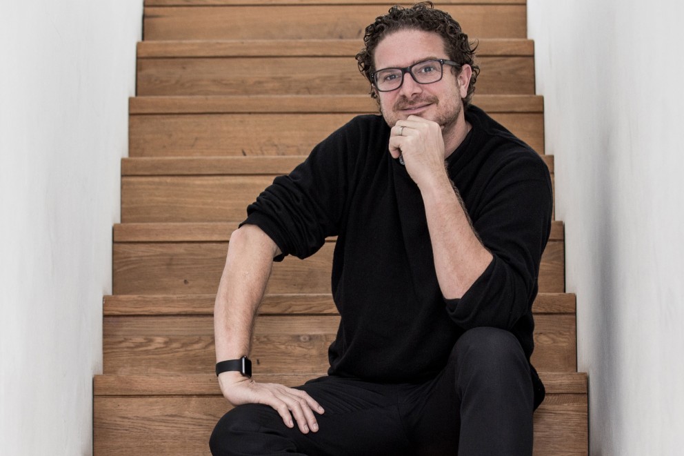 Michael Hecken, inventeur, designer et créateur, assis sur un escalier.
