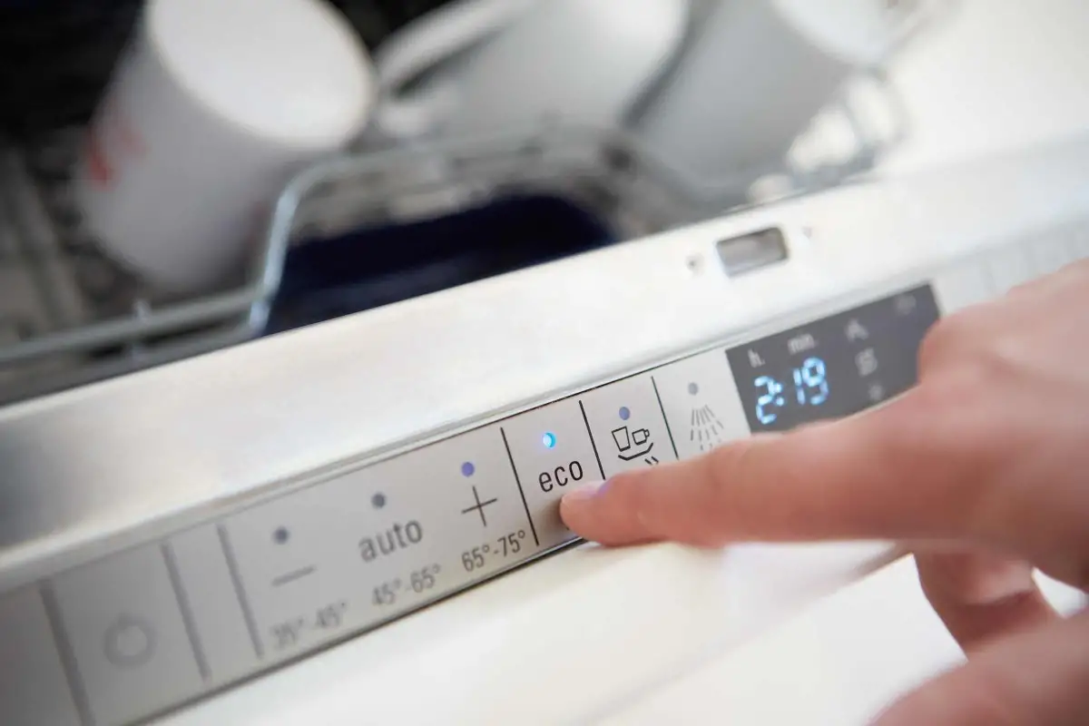 Bedienfeld eines Geschirrspülers mit Fokus auf die Eco-Taste und digitaler Anzeige der Uhrzeit
