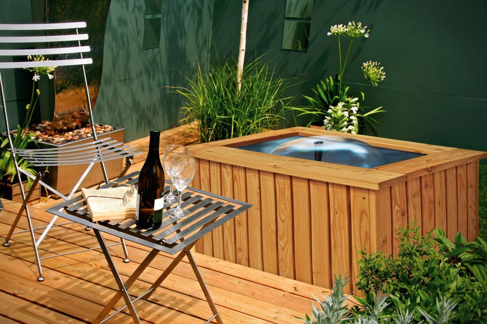 
				Quadratischer Terrassenteich auf einer Holzterrasse mit Gartenmöbeln aus Metall

			