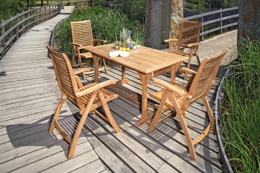 Gartenszene mit Teakholztisch und vier Stühlen auf Holzterrasse