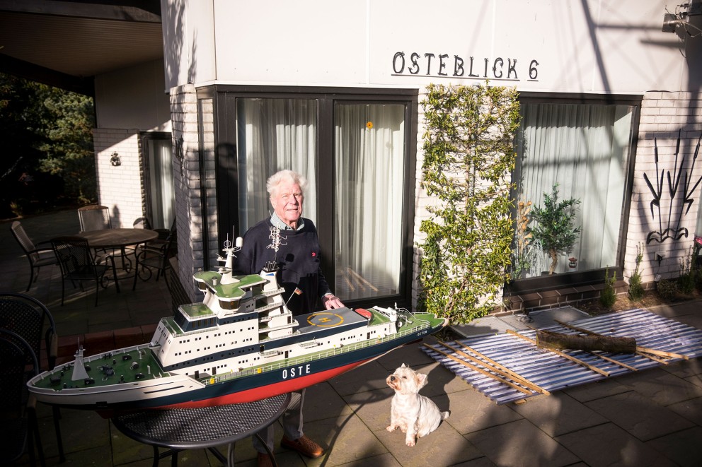 
				Lothar avec son chien devant sa maison avec la maquette du «Oste».

			