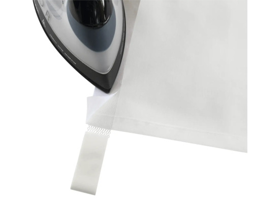 Fer à repasser repassant l''ourlet d''un rideau