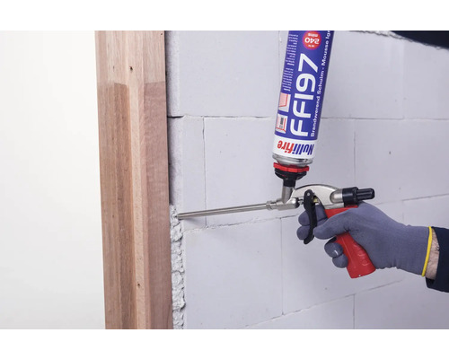 Application de mousse coupe-feu au pistolet entre le cadre de porte et la maçonnerie