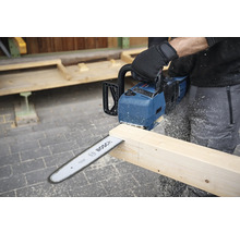 Une personne scie une planche de bois avec une tronçonneuse à batterie Bosch.