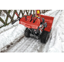 Fraise à neige rouge sur un chemin enneigé.