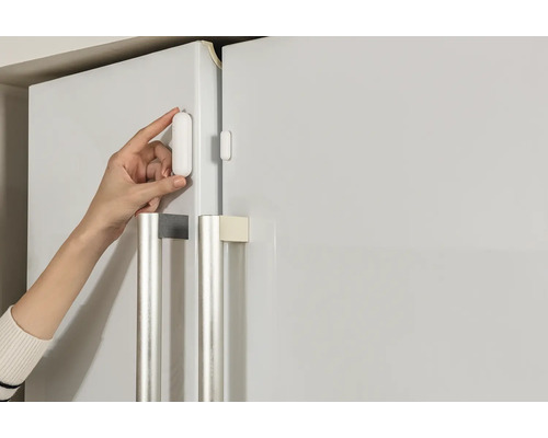 Installation d''un détecteur de porte et de fenêtre sur un réfrigérateur.