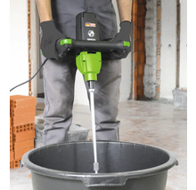 Personne utilisant un mélangeur à mortier dans un seau.