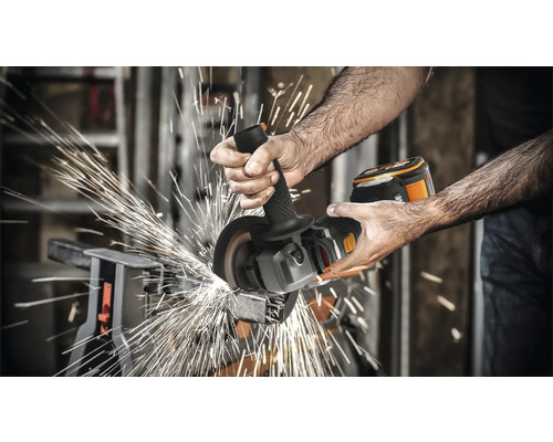 Mann schleift Metall mit einem Akku-Winkelschleifer, Funken sprühen