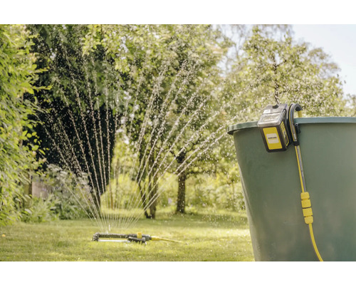 Scène d''arrosage avec pompe d''arrosage Kärcher et arroseur dans le jardin
