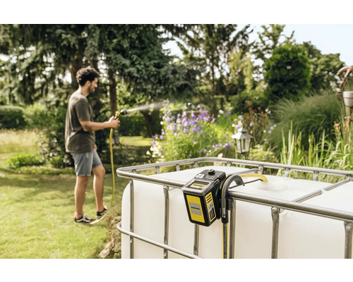 Arrosage du jardin avec une pompe d''arrosage de jardin Kärcher sur un conteneur IBC dans le jardin.