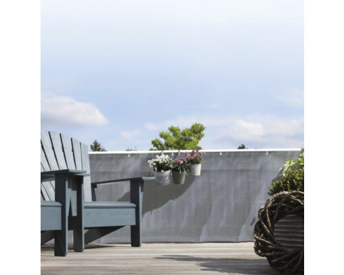 Balkonszene mit grauem Sichtschutz, Holzstuhl und Pflanzen