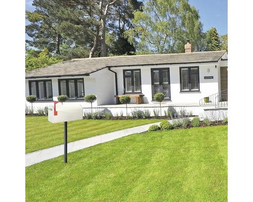 Une maison avec une pelouse soignée et une boîte aux lettres