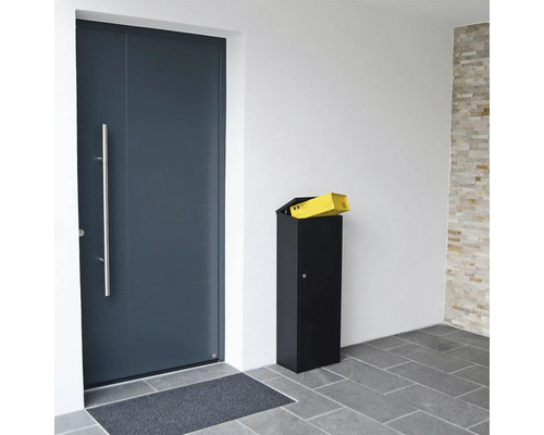 Boîte aux lettres sur pied à côté d''une porte d''entrée avec une lettre sur le dessus