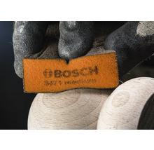 Bosch Schleifpad wird von einer Hand mit Schutzhandschuh gehalten