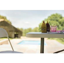 Gartenszene mit Tisch, Stuhl, Soßenflaschen und Geschirr im Freien