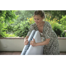 Frau klappt einen weissen Klapptisch zusammen, ideal für Partys und Veranstaltungen im Freien.