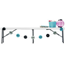 Table pliante blanche décorée avec vaisselle, lanternes et guirlandes