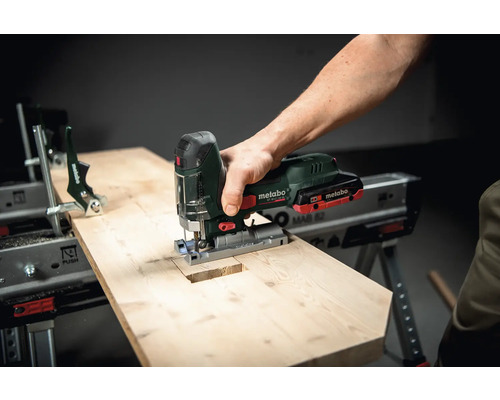 Une scie sauteuse Metabo coupe un morceau de bois sur un établi