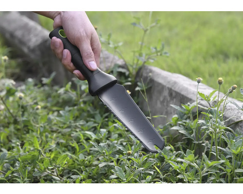 Une main tient un couteau de jardin pour désherber.