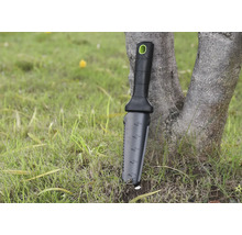 Outil de jardinage avec manche et échelle de mesure appuyé contre un arbre