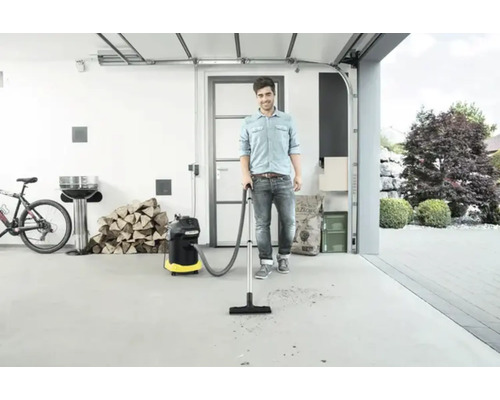 Un homme passe l''aspirateur dans un garage avec un aspirateur multi-usage