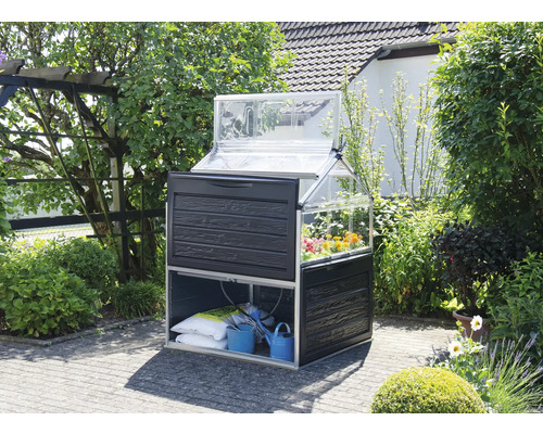 Serre avec table de culture et rangement dans le jardin.