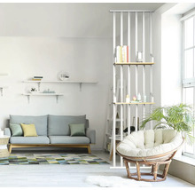 Espace de vie lumineux avec canapé, étagères et fauteuil en rotin