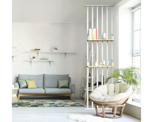 Espace de vie lumineux avec canapé, étagères et fauteuil en rotin