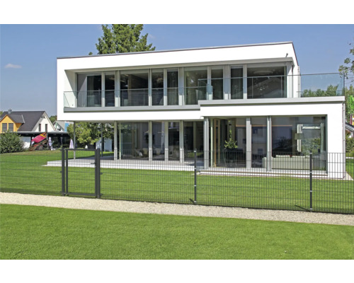 Maison moderne avec clôture en treillis métallique double pour délimiter la propriété