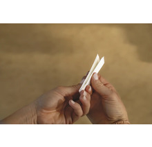 Eine Person hält eine Messlatte in der Hand.