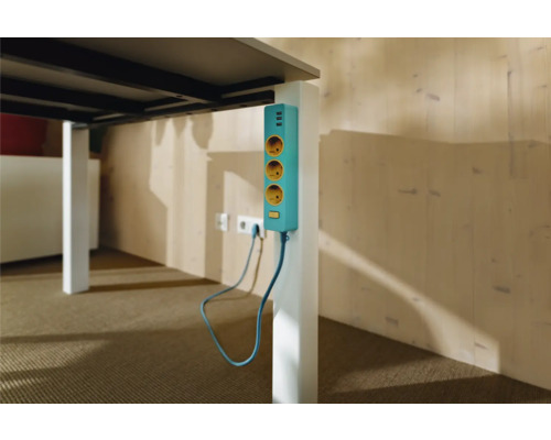 Mehrfachsteckdose mit USB-Anschlüssen an einem Tischbein befestigt