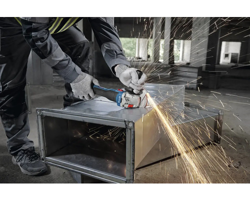 Handwerker schleift Metall mit einem Winkelschleifer, Funken fliegen.