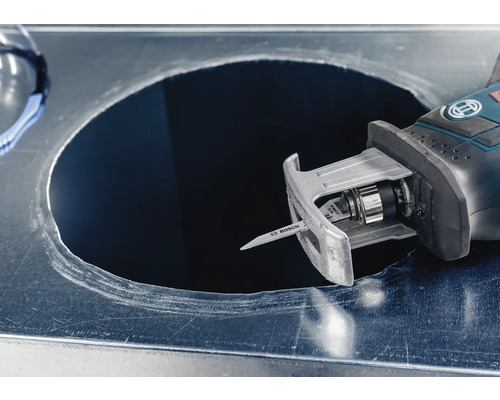 Une scie sauteuse coupe un trou dans une tôle.