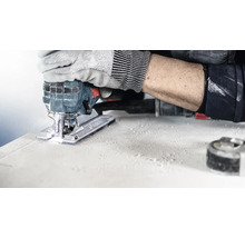 Une scie sauteuse en cours d''utilisation pour couper une pièce, actionnée par une personne portant des gants de travail.