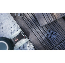Bosch Logo. Detailaufnahme eines Multitools beim Kürzen von Terrassendielen.