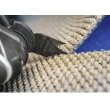 Outil multifonction Bosch coupant une moquette