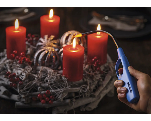 Adventskranz mit vier brennenden Kerzen und ein Stabfeuerzeug in einer Hand