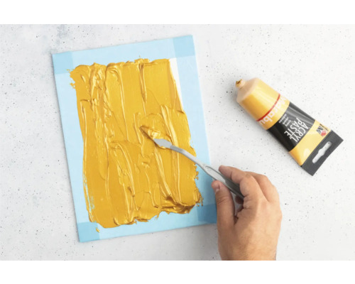 Application de pâte acrylique sur une toile avec un couteau à peindre