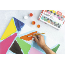 Peintures acryliques, pinceau et toile peinte sur une surface de travail