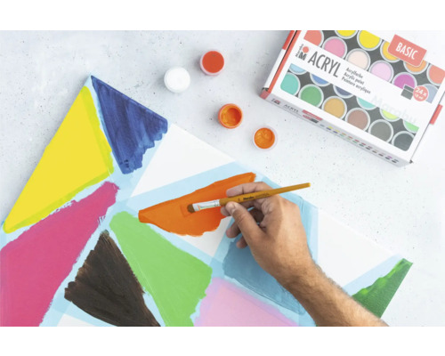 Peintures acryliques, pinceau et toile peinte sur une surface de travail