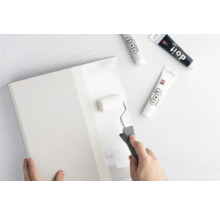 Person streicht eine Platte mit einem Farbroller und Farbe von Do it