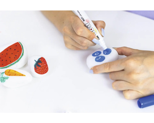 Bemalte Steine mit Obstmotiven und eine Person, die einen Stein mit einem Stift bemalt.