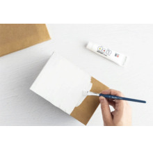 Anstreichen einer Pappschachtel mit Farbe und einem Pinsel.