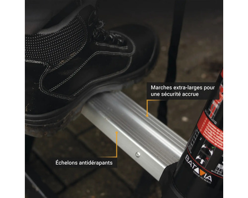 Gros plan d''un escabeau avec des marches antidérapantes sous une chaussure de travail